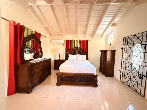 a bedroom with a bed and a dresser and a mirror at 5 BedRmOasis DraxHall Pool Gym in Mammee Bay