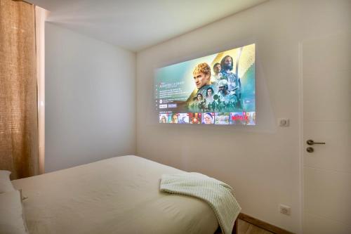 a bedroom with a flat screen tv on the wall at L'escale Mourillon - Plage, Balnéo & Soleil in Toulon