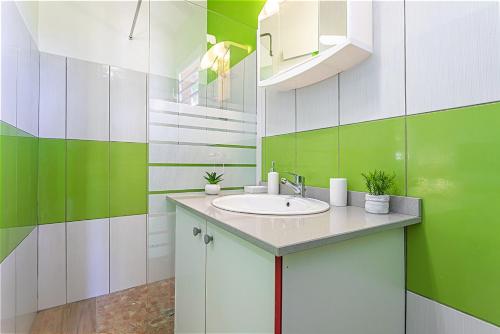 a bathroom with a sink and green and white walls at Gîte Dalina Sainte-Rose in Sainte-Rose