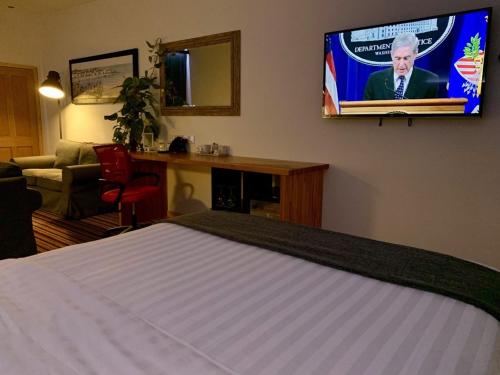 a bedroom with a bed and a tv on the wall at The Waterfront Lodges in Coventry