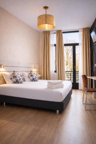 a bedroom with a large bed and a large window at Hotel Le Centenaire Brussels Expo in Brussels