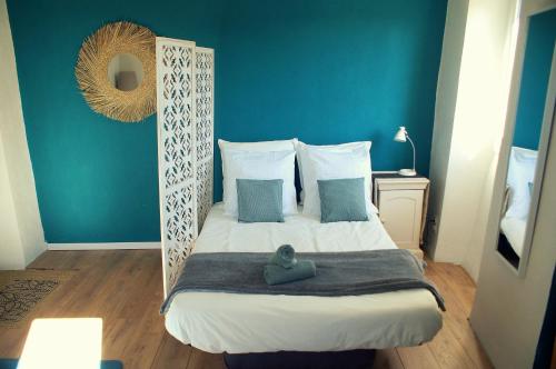 a bedroom with a large bed with blue walls at Le Mazet d'Aurore in Chassiers