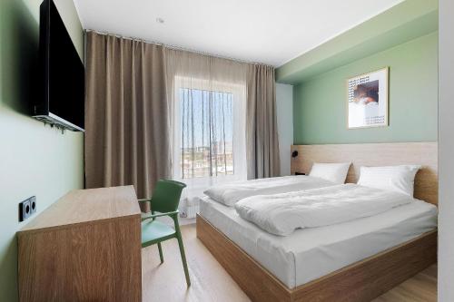 a bedroom with a bed and a desk and a television at Aiden by Best Western Odense in Odense