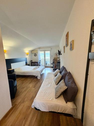 Studio à Saint-Florent في سانت فلوران: غرفة كبيرة بها سريران وأريكة