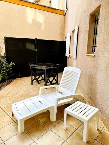 two white chairs and a table on a patio at "L'olivier" - Résidence Rive Gauche in Les Salles-sur-Verdon