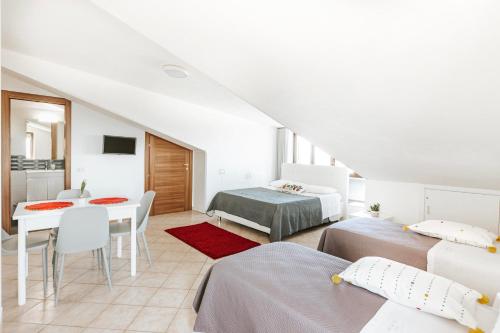 a white room with two beds and a table at Da Micchele Rooms in Vasto