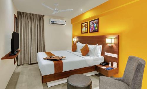 a hotel room with a bed and a tv at Best Western Alkapuri, Vadodara in Vadodara