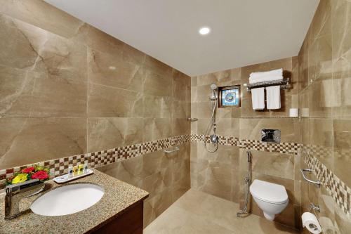 a bathroom with a sink and a toilet and a shower at Best Western Alkapuri, Vadodara in Vadodara