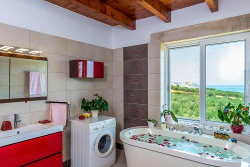 a bathroom with a tub and a washing machine at Villa Chara Chania in Agia Marina Nea Kydonias