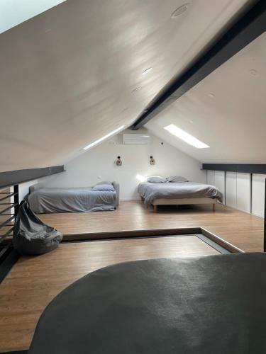 a room with two beds in a room at Loft industriel avec jacuzzi in Le Bourgeat