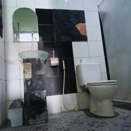 a bathroom with a toilet and a sink at Palagan Boutique Hotel in Ngaglik