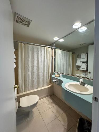 a bathroom with a sink and a toilet and a mirror at Wild Dunes Inn in Ocean City