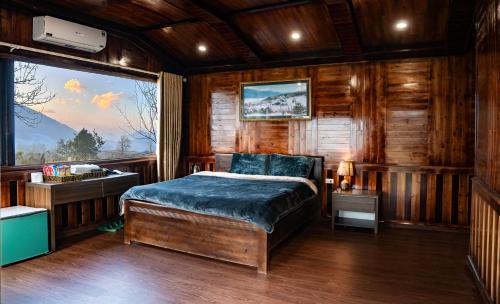a bedroom with a bed and a large window at Bản Mận Retreat in Sapa