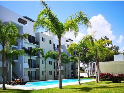 a group of people sitting next to a building with palm trees at NEFELI departamento by Xenia Caribe in Playa del Carmen