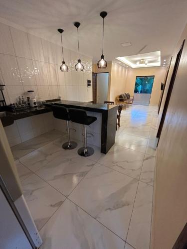 a kitchen with a black counter and a white tile floor at Refúgio do Mar in Ilhéus