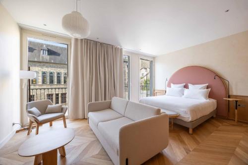 a hotel room with a bed and a chair at Boutique-Hôtel Le N3 par Champagne Thiénot in Reims
