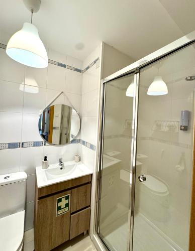 a bathroom with a shower and a sink and a mirror at Charming Cozy Retreat - Terrace & Private Balcony in Coimbra