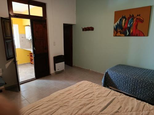 a bedroom with a bed and a door to a hallway at Glamaué 2 in Carhué
