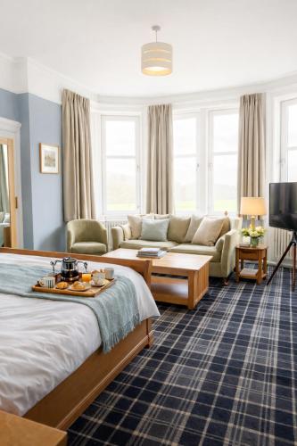 a hotel room with a bed and a couch at Friars Carse Country House Hotel in Dumfries