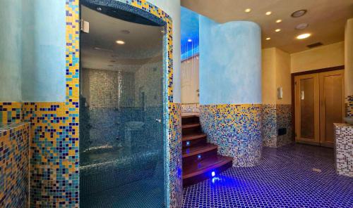 a bathroom with a walk in shower and a staircase at Ashanti Aparthotel Wellness&Spa in Bibione