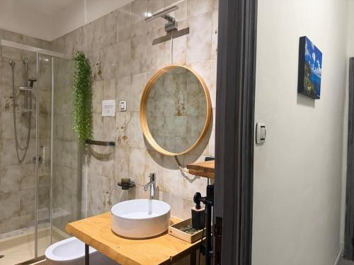 a bathroom with a sink and a shower with a mirror at Affittacamere Osimo Rose in Osimo