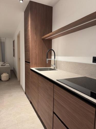 a kitchen with wooden cabinets and a sink at Paradis Apartments in Dubrovnik