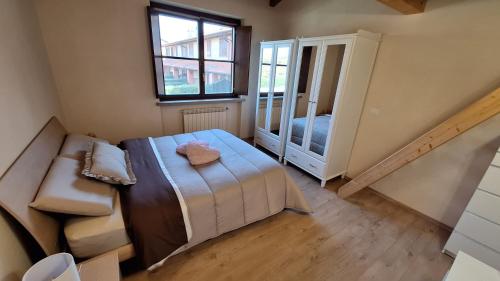 a small bedroom with a bed and a mirror at Villa Elisa in Saluzzo
