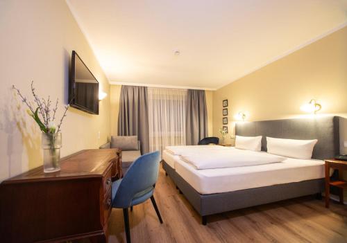 a hotel room with a bed and a desk at Hotel Altmünchen by Blattl in Munich