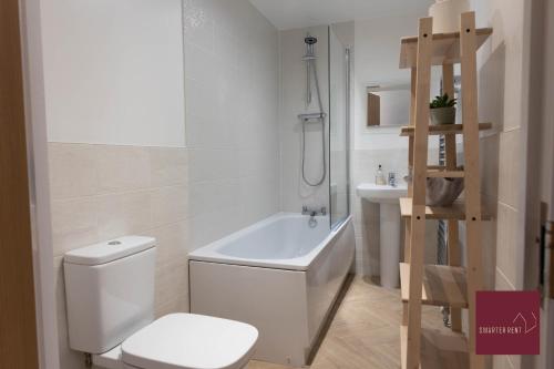 a white bathroom with a toilet and a sink at Hook Three Bed Flat Parking in Hook