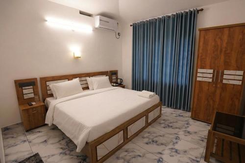 a bedroom with a large bed and a television at Sea View Varkala Beach Resort in Varkala