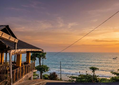 a house with a view of the ocean at sunset at Sea View Varkala Beach Resort in Varkala