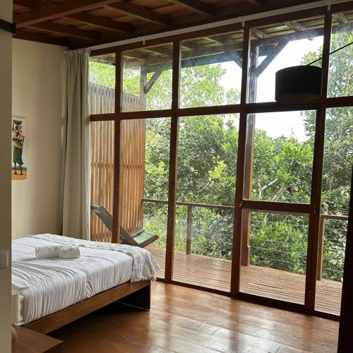 sypialnia z łóżkiem i dużym oknem w obiekcie Roça Vale dos Prazeres w mieście São Tomé
