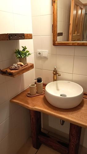 a bathroom with a white sink on a wooden counter at Penzion PROVANS - Pálava in Dolní Dunajovice