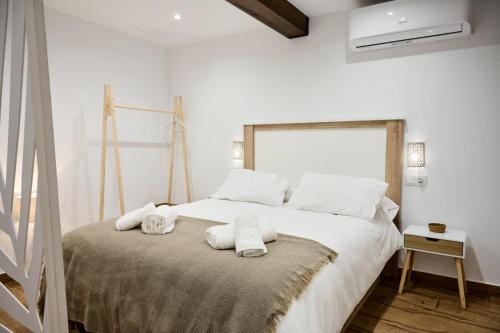 a white bedroom with a large bed with towels on it at La Maestra Catedral 1 in Jaén