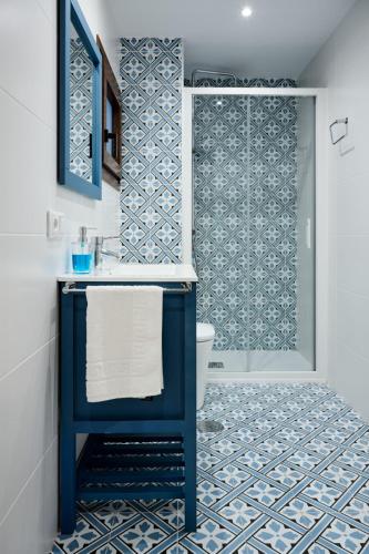 a bathroom with a blue sink and a shower at La Maestra Catedral 1 in Jaén
