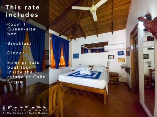 a bedroom with a bed with a blue and white blanket at Hotel de Campo Caño Negro in Caño Negro