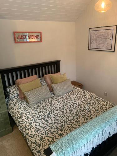a bed in a bedroom with ajust living sign on the wall at 1 mile from Harry Potter Tour Self Contained Flat One bedroom plus new sofa bed in lounge in Abbots Langley