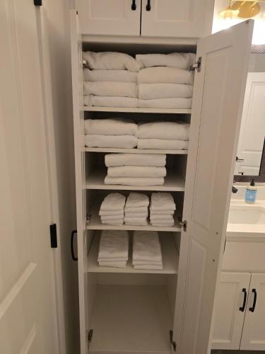 a closet filled with white towels in a bathroom at Waterfront Retreat One in Rocky Mount