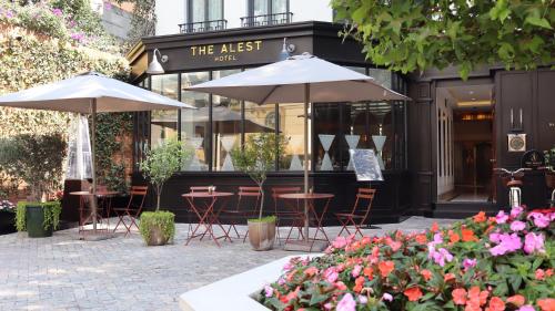 two tables and umbrellas in front of a restaurant at The Alest Hotel in Mexico City