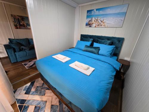 a blue bed with two towels on top of it at Moderna smeštaj Kula in Kula