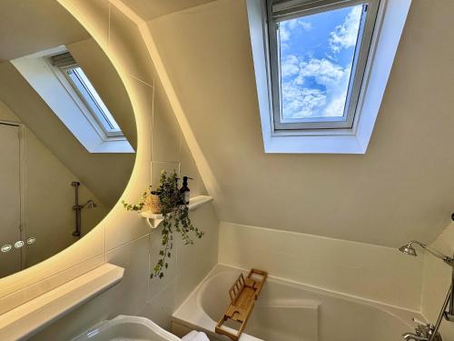 a bathroom with two windows and a tub and a sink at Manoir du Val Riant in Saint Malo