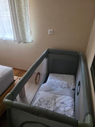 a baby crib in a room with a bed at Heimathaus Hettegger in Grossarl