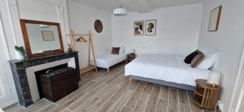 a bedroom with a bed and a mirror and a fireplace at Maison du Gué 2 chambres in Gurgy