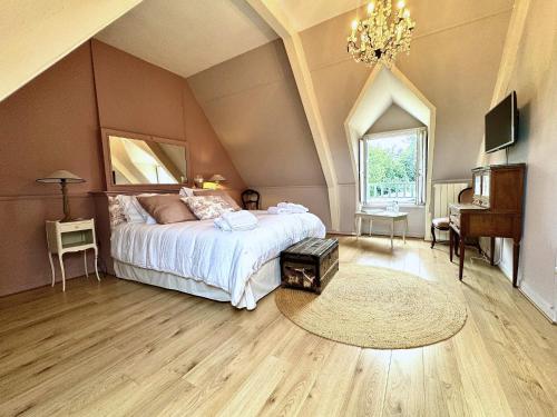 a bedroom with a large bed and a table at Manoir du Val Riant in Saint Malo