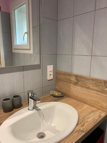 a bathroom with a white sink and a mirror at La Escala in La Celle-sous-Gouzon