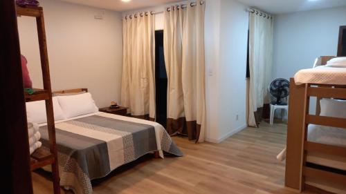 a bedroom with a bed and two bunk beds at Recanto dos Sonhos in Paraty