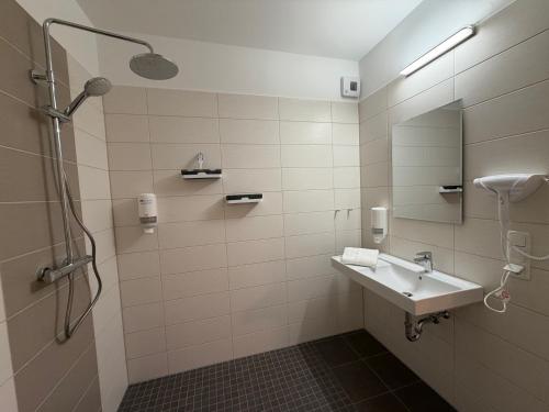 a bathroom with a sink and a shower at City Inn Schwedt in Schwedt