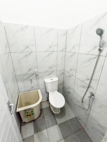a white bathroom with a toilet and a sink at I am Backpacker Hostel in Sabang