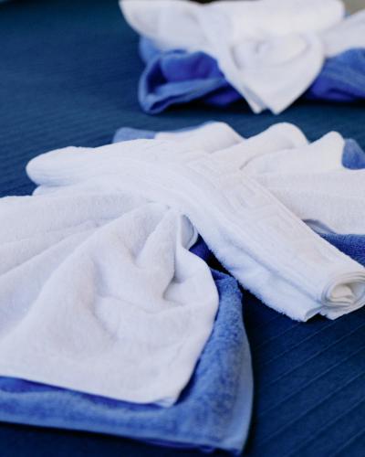 a pile of white towels sitting on a bed at Villa Sofia Almyrida in Almyrida