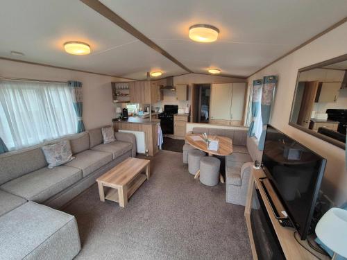 a living room with a couch and a table at Dornoch Holiday Chalet in Proncy